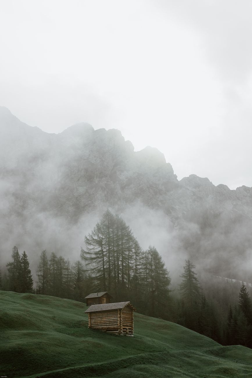 Remote mountain lodge in early morning mist
